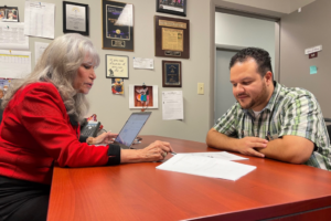 HEA founder Sylvia Alvarez reviews a document Alvin Martinez who became a homeowner with the help of HEA. Martinez is now a housing counselor in-training at the agency.